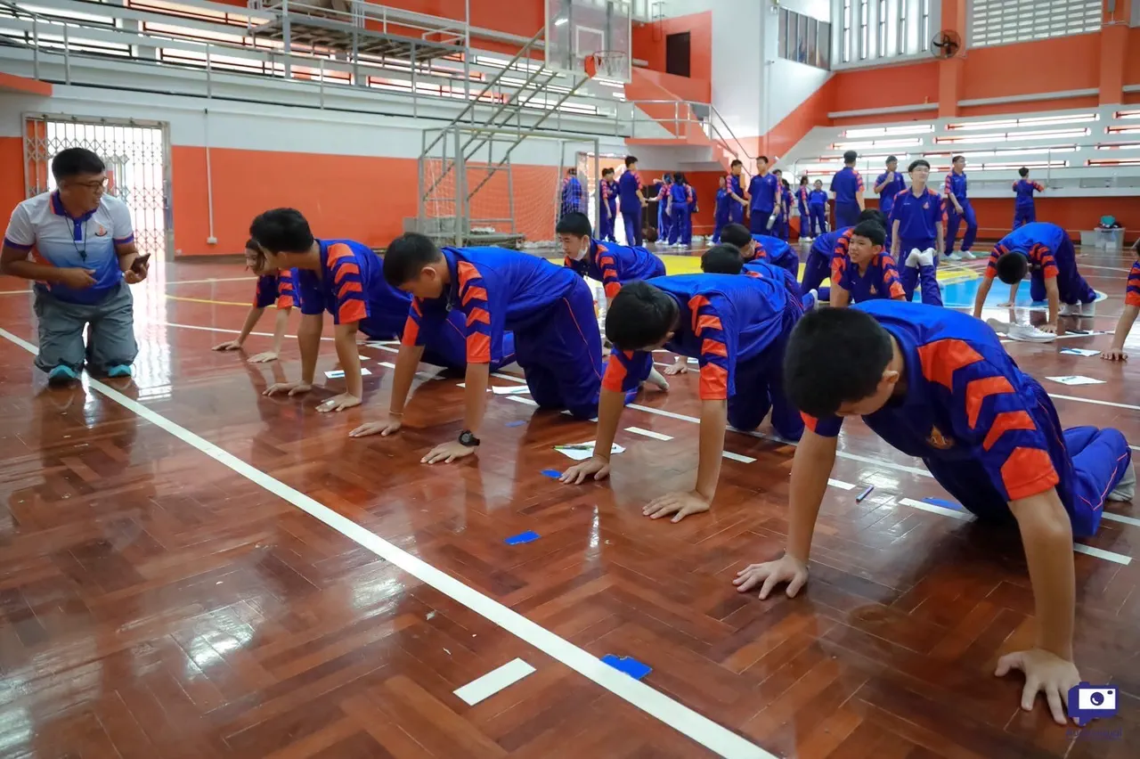 กลุ่มนักเรียนทำแบบทดสอบดันพื้นในโรงยิมของโรงเรียน